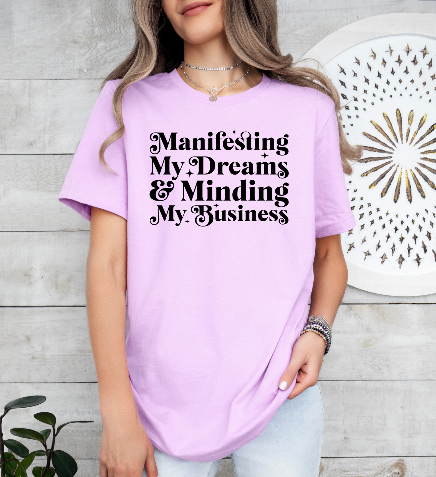 a woman wearing a t - shirt that says manifising my dreams and minds