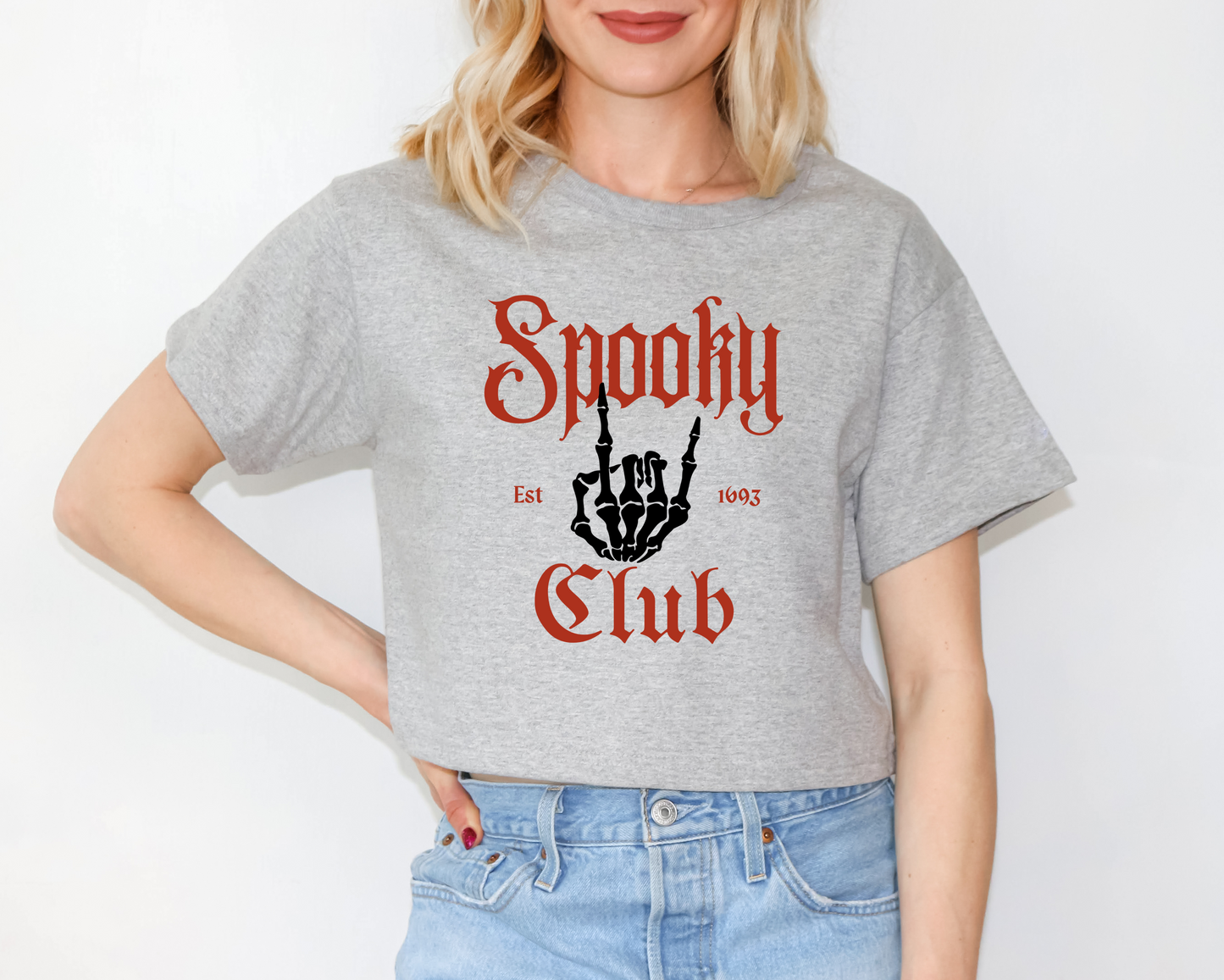 a woman wearing a grey shirt that says spooky club