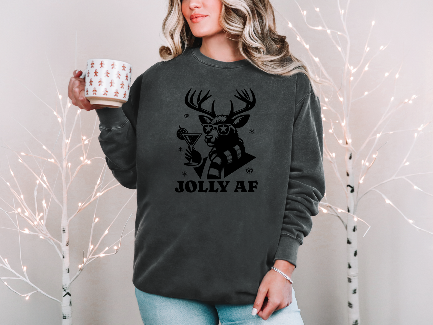 a woman holding a cup of coffee while wearing a sweatshirt