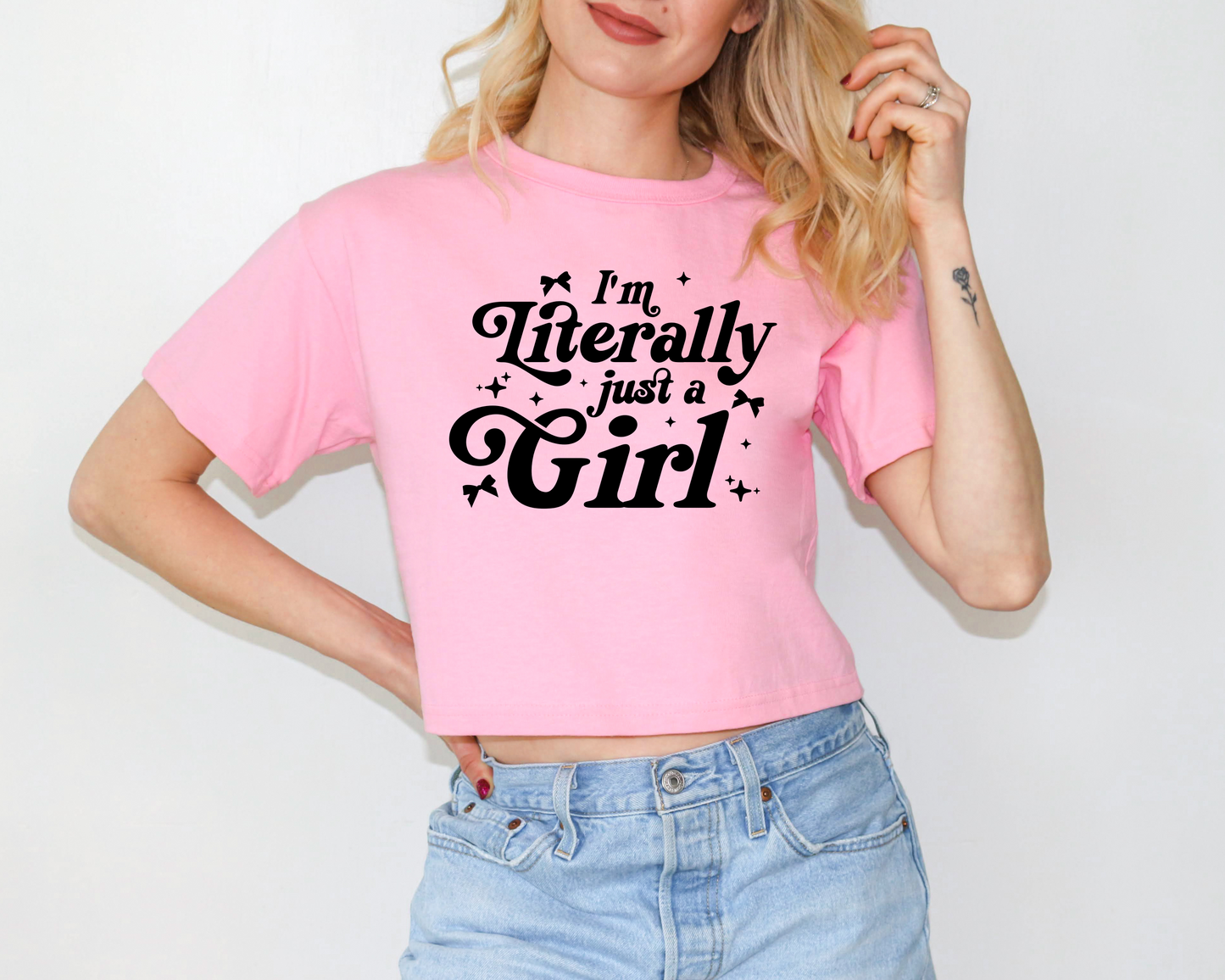 a woman wearing a pink shirt that says i'm literally just a girl