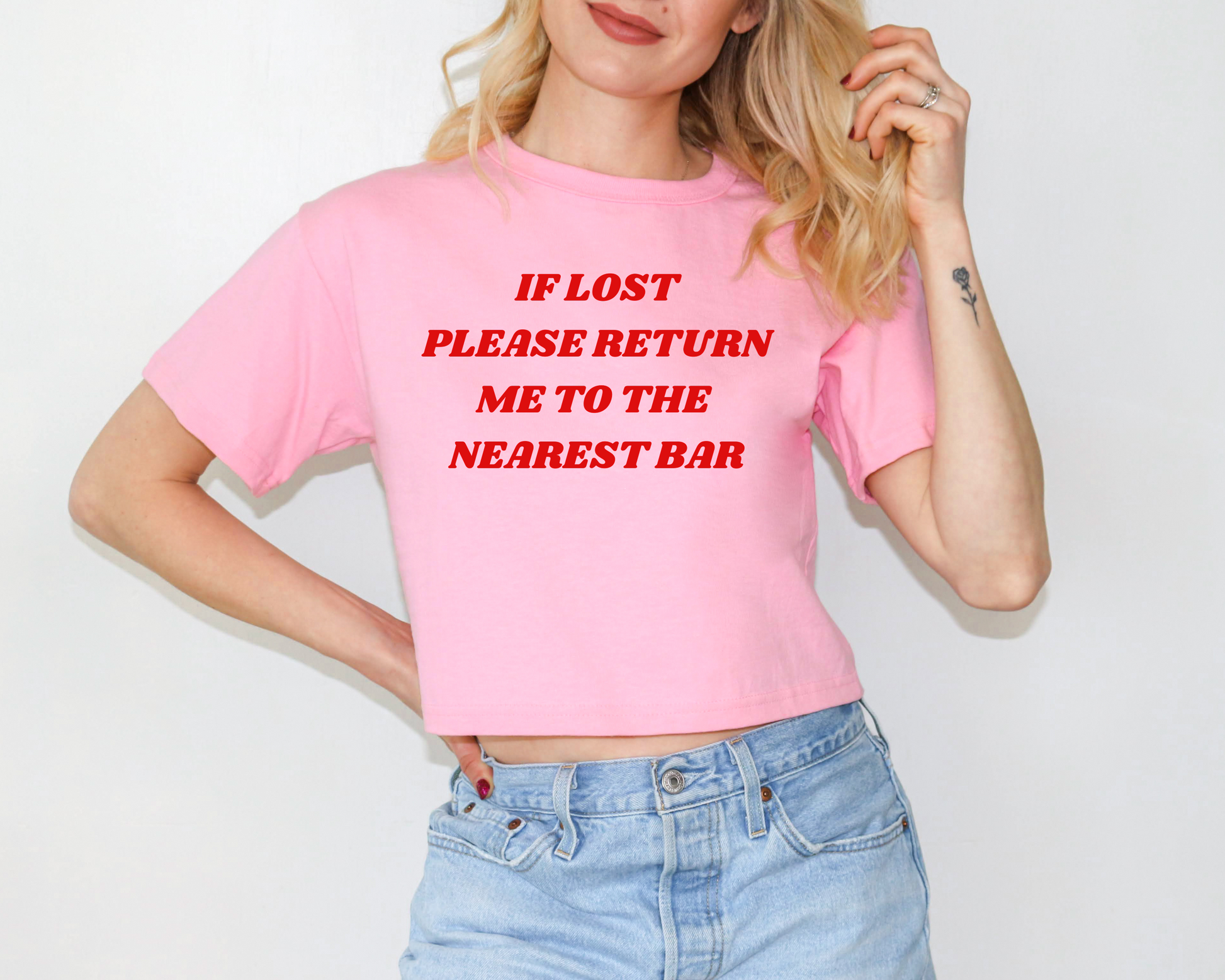 a woman wearing a pink t - shirt that says, if lost please return me