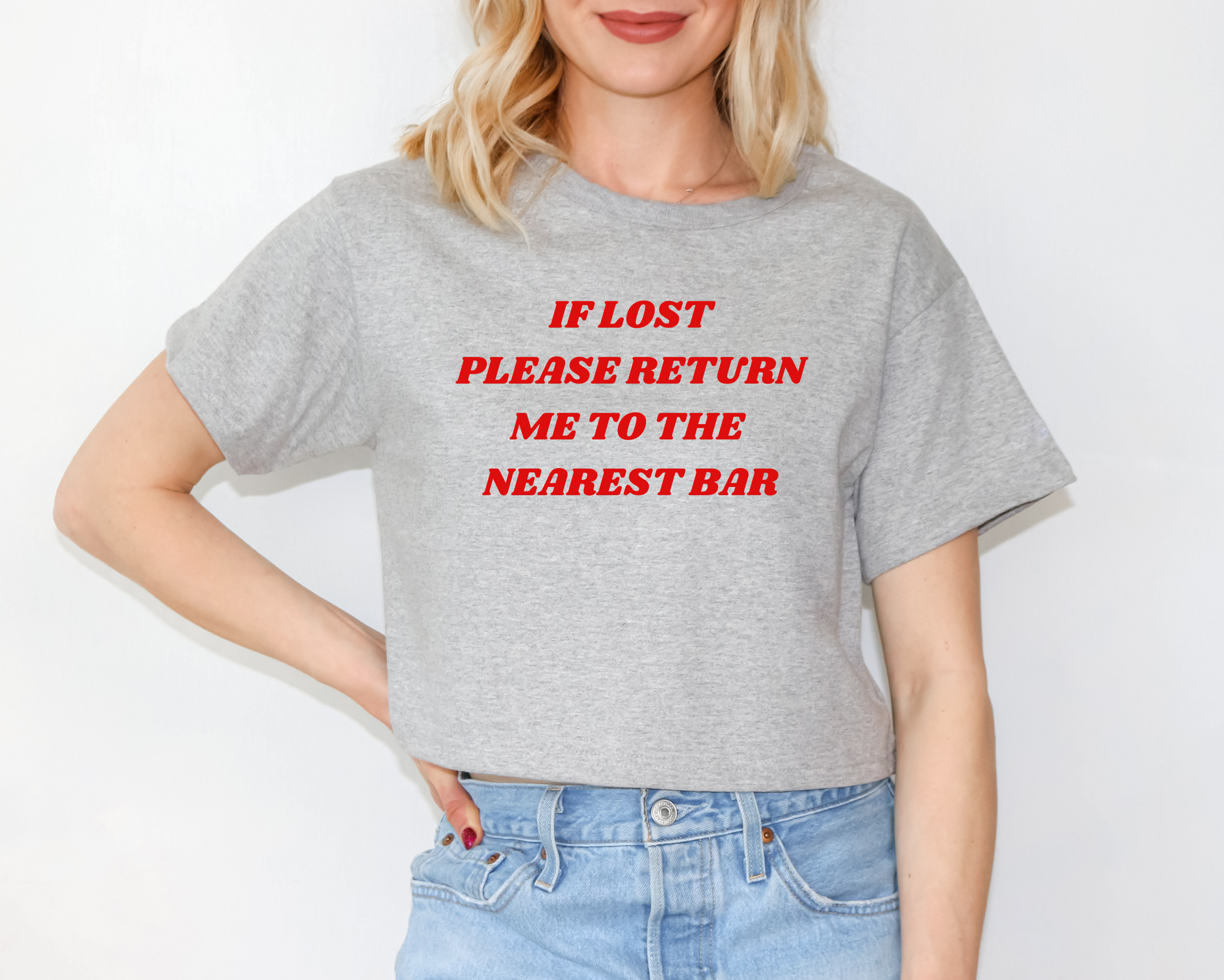 a woman wearing a grey t - shirt that says if lost please return me to