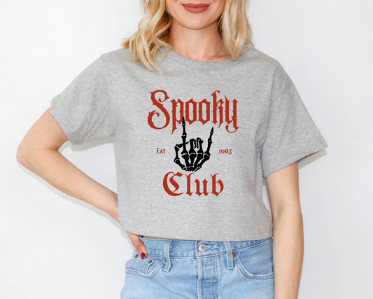 a woman wearing a grey shirt that says spooky club