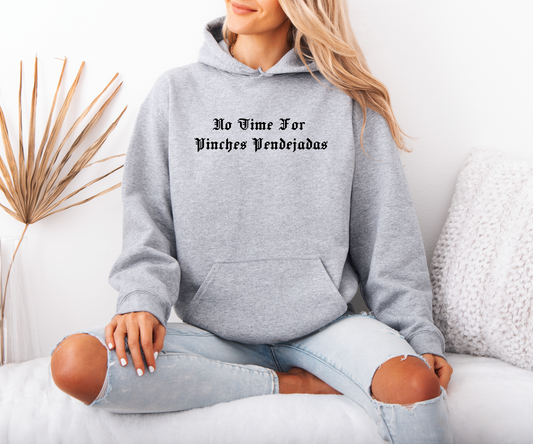 a woman sitting on a couch wearing a grey hoodie